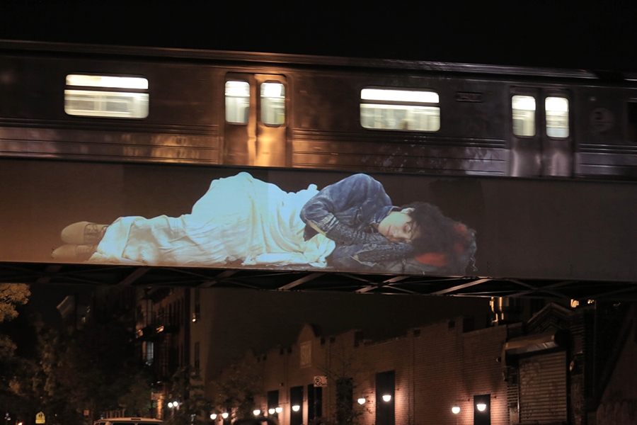 large video projection of person napping above empire diner